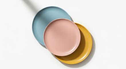 Three stacked matte finish ceramic plates in pastel blue dusty rose and mustard yellow colors dishware