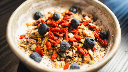 Nutrient-packed yogurt bowl with crunchy granola, mixed seeds and fresh blueberries. Perfect healthy breakfast for food blogs and lifestyle content