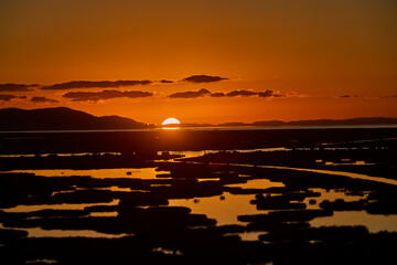 First light breaks over Lake Titicaca, painting the waters and Andes in hues of gold and rose — a...