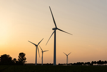 Wind turbines silhouettes against sunset sky