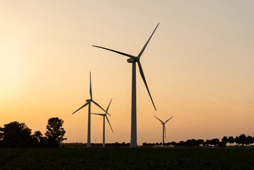 Wind turbines silhouettes against sunset sky