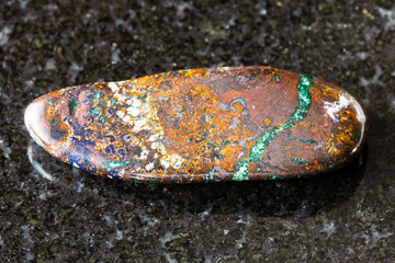 sample of polished zarinite rock on black granite