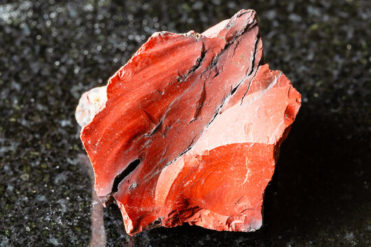 sample of raw red mookaite mineral on black