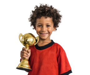 A young boy is happily celebrating a victory while holding a golden trophy.