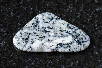 sample of polished foyaite rock on black granite
