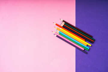 crayons de couleur multicolores sur fond rose et violet