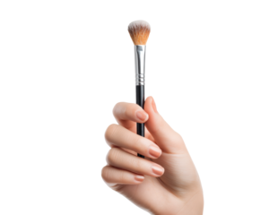 A hand holding a makeup brush on a black backdrop.