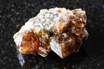 sample of raw hessonite grossular rock on black