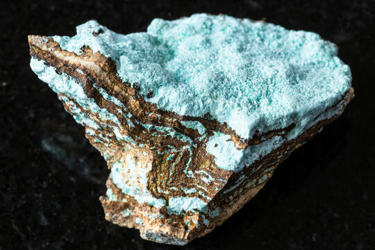 sample of raw aurichalcite rock on black granite