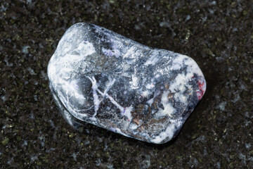 sample of polished antimonite rock on black