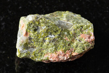 sample of raw unakite rock on black granite