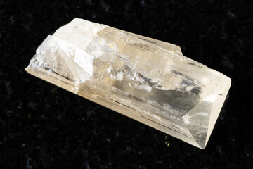 sample of rough danburite mineral on black granite