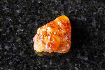 sample of raw scheelite mineral on black granite