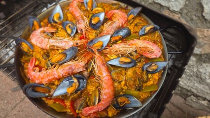 Traditional spanish paella with seafood including shrimp and mussels on rustic background. Typical...