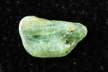 sample of tumbled green kyanite rock on black