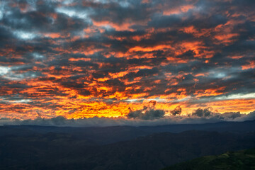 Fiery dawn ignites the sky over the Andes, as seen from the ancient citadel of Kuélap — a...