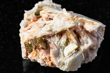 sample of albite rock with muscovite mica on black