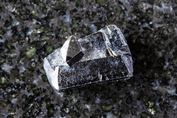 sample of natural ilvaite mineral on black granite