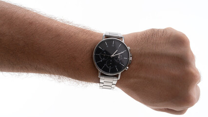 Classic silver watch displayed on wrist in a bright setting with focus on the elegant design and...