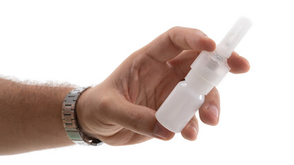 Hand holding a small spray bottle for nasal inhalation in a clinical setting during daytime