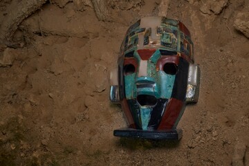 Colorful Ancient Mosaic Mask Unearthed in Dirt Embodying Historical Artistry and Cultural...