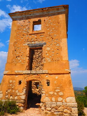 Requena,19th century telegraph tower in Mediterranean countryside, historic communication building under bright blue sky 
