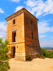 Requena,19th century telegraph tower in Mediterranean countryside, historic communication building under bright blue sky 