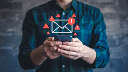 Man receives urgent email alerts on smartphone, highlighting digital communication dangers and security concerns.