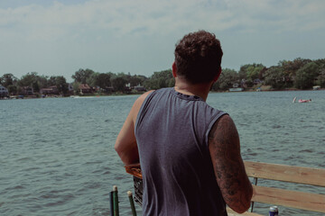cute tattoo man on the lake dock