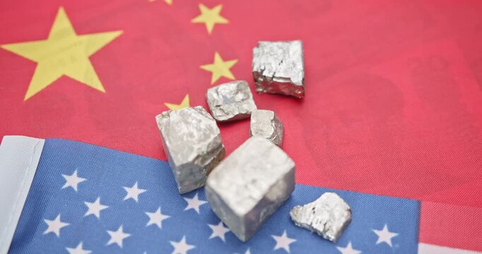 Metallic ore fragments - likely rare earth or strategic materials - laid atop overlapping Chinese and American flags. Shifting the balance in escalating China - U.S. trade and policy negotiations.