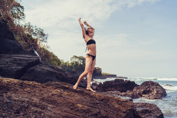 Arms raised upward, woman visualizes signal amplification, like biometric antenna syncing with...