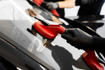 Windshield Installation Using Suction Lifters. Two technicians install windshield using suction...