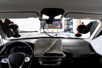 Windshield Installation Using Suction Lifters. Two technicians install windshield using suction...