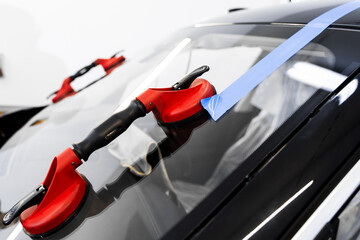 Windshield replacement using lifting tools that grip glass securely. Windshield technicians rely on...