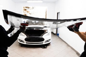 Windshield Installation Using Suction Lifters. Two technicians install windshield using suction...