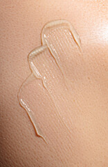 Fototapeta premium swatch of blue transparent gel on skin background, macro texture of the skin on which the gel is applied