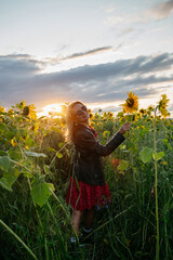A woman walking through a field of sunflowers