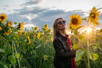 A woman walking through a field of sunflowers