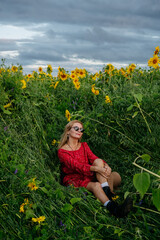 A woman walking through a field of sunflowers