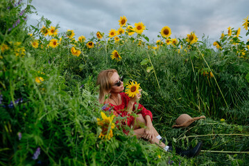 A woman walking through a field of sunflowers
