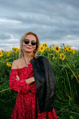 A woman walking through a field of sunflowers