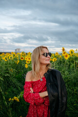 A woman walking through a field of sunflowers