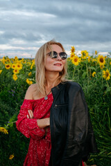 A woman walking through a field of sunflowers