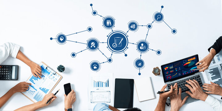 A high-angle view of a collaborative business meeting showcasing the analysis of data through charts and graphs, reflecting modern strategies and teamwork in a conference setting. Amity