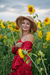 A woman walking through a field of sunflowers