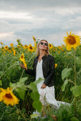A woman walking through a field of sunflowers