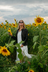 A woman walking through a field of sunflowers