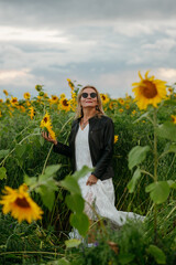 A woman walking through a field of sunflowers