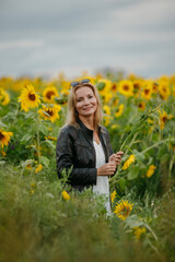 A woman walking through a field of sunflowers