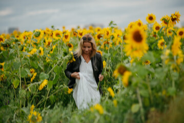 A woman walking through a field of sunflowers